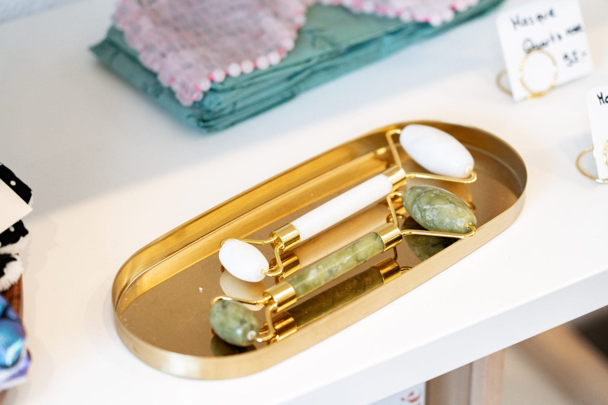 Rouleaux de massage pour le visage sur un plateau doré dans la boutique Swiss Co’Labs à Chavornay